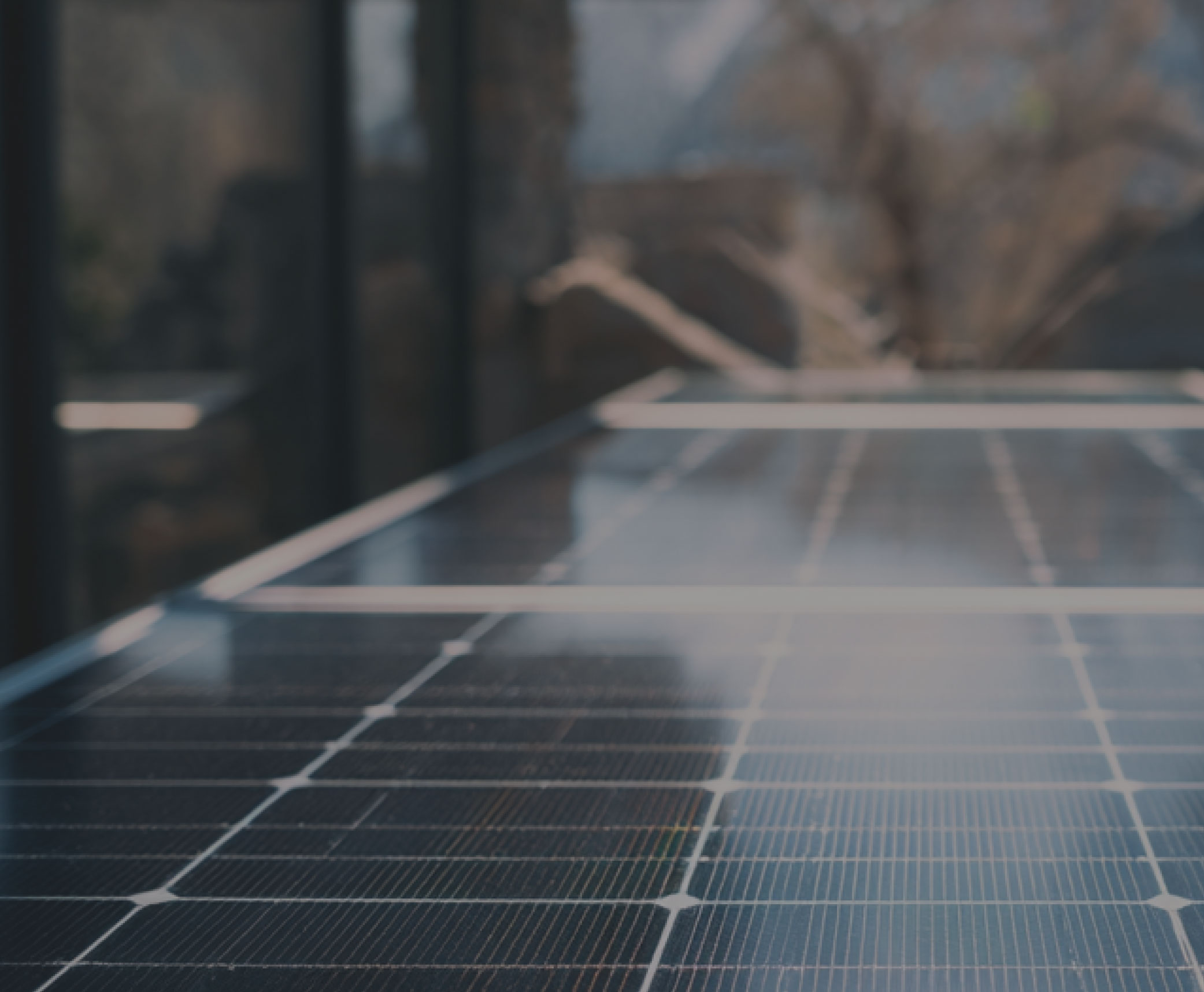 Blurred view of a ground-mounted solar panel array in an outdoor installation, suggesting a solar farm.